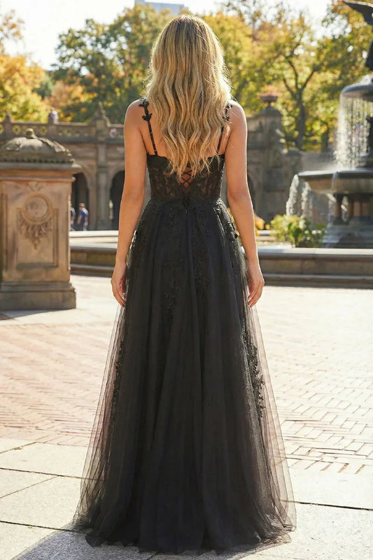 Back view of Sevoba black lace tulle evening gown showing a lace-up corset back and flowy floor-length skirt, outdoor setting