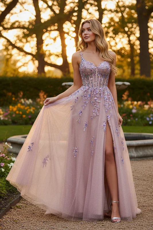 Woman in a lilac embellished tulle prom gown with floral appliqué and high slit, outdoors at sunset
