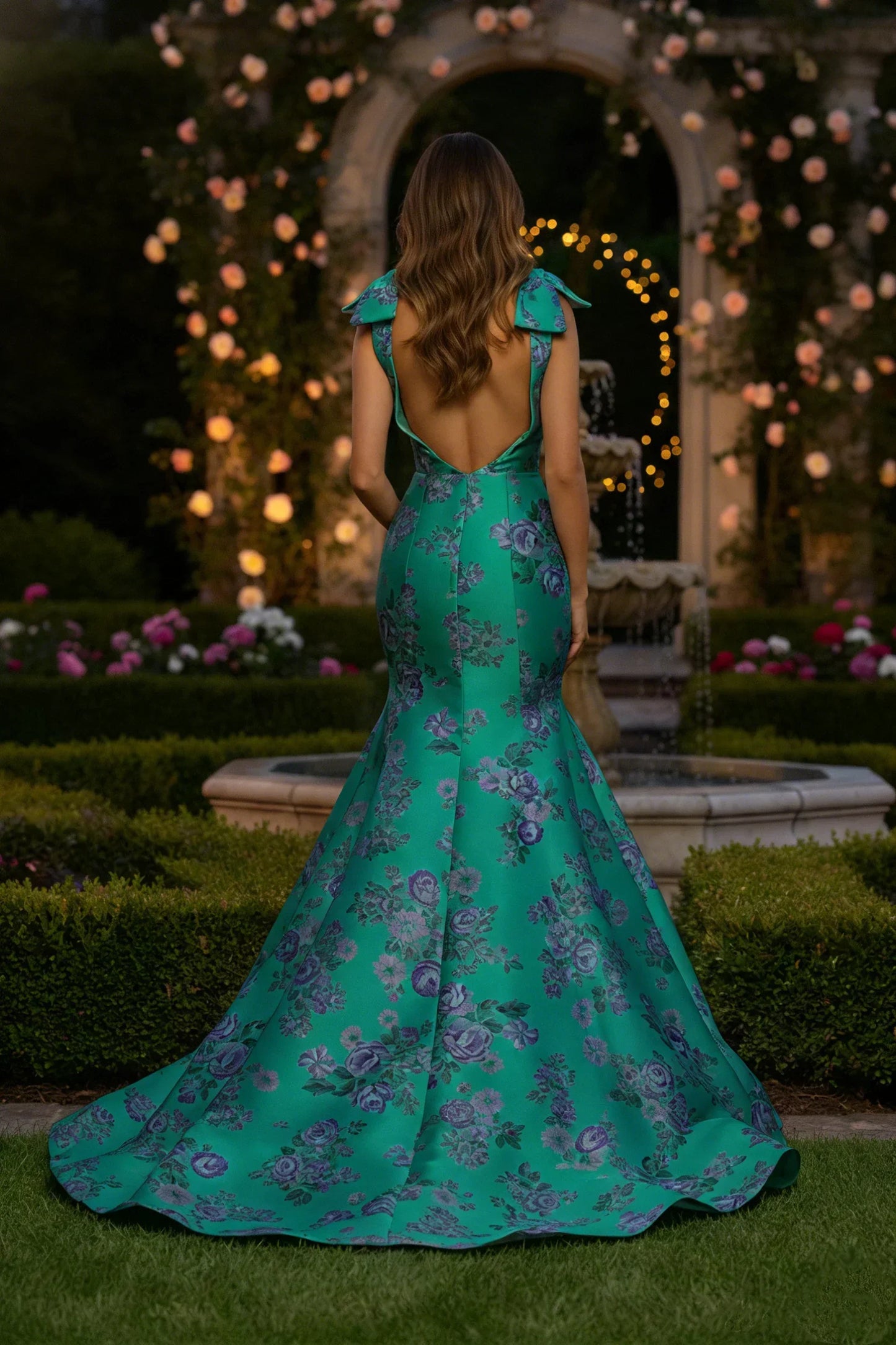 Woman in an elegant green floral mermaid gown at a garden evening event