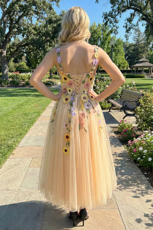 Back view of a woman in a 3D floral tulle ankle-length prom dress outdoors