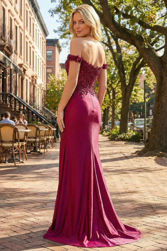 Back view of Sevoba wine red satin evening gown showing a sheer lace back and floor-length skirt, city background