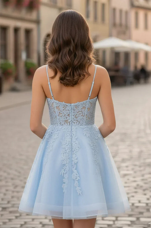 Back view of a woman in a light blue A-line spaghetti strap lace homecoming dress outdoors
