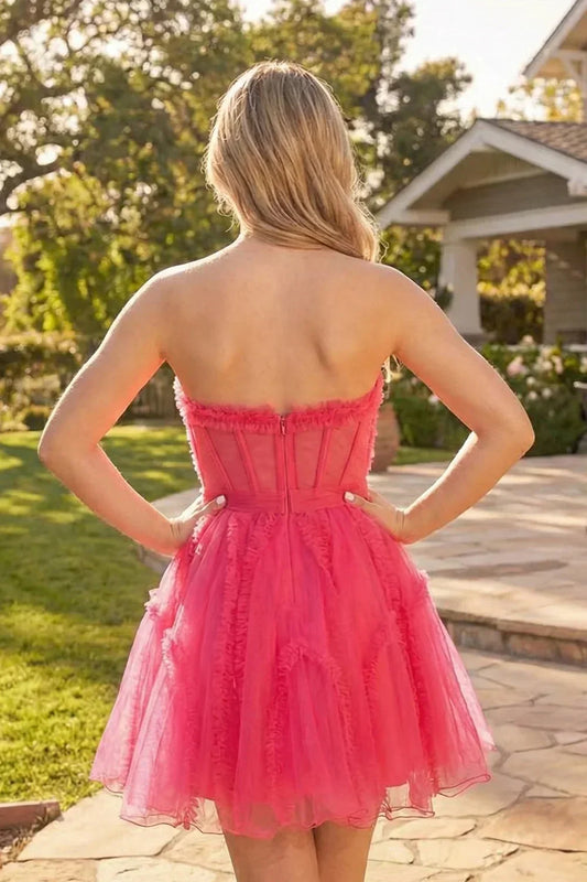 Back view of a strapless fuchsia tulle A-line homecoming dress outdoors