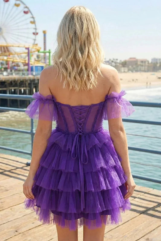 Woman in a purple off-the-shoulder ruffle tiered homecoming dress by the beach