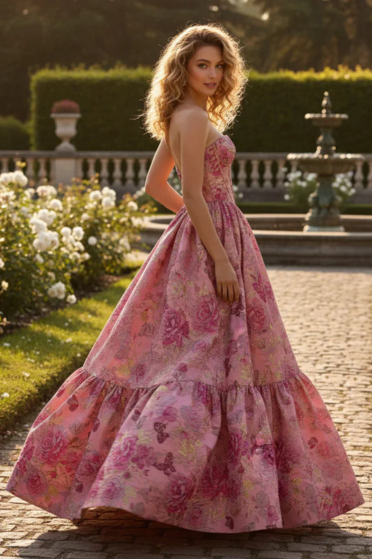 A-line strapless pink prom dress with floral and butterfly patterns in a garden setting.
