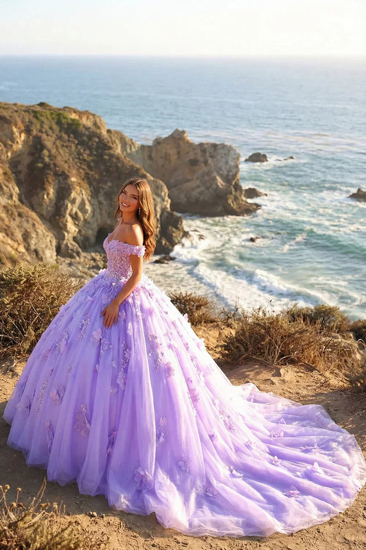 Young woman in a lilac ball gown with 3D floral lace details by the seaside cliffs.