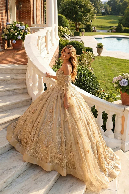 Woman in gold off-the-shoulder A-line tulle gown with 3D floral details on marble stairs outdoors