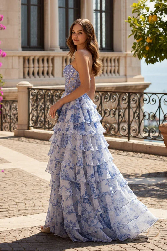 Woman in a blue and white floral tiered A-line prom dress with sweetheart neckline outdoors