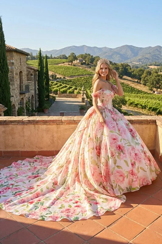 Elegant floral ball gown with cold shoulder design, full skirt, and tiara in outdoor vineyard setting