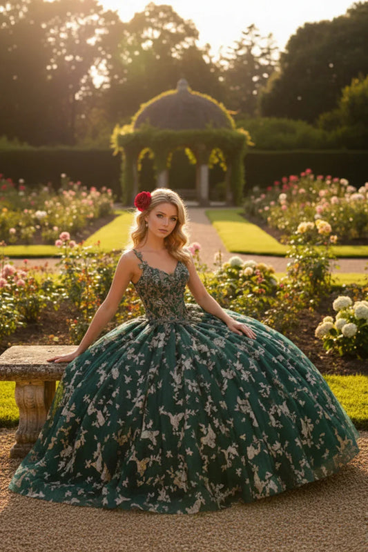Woman in a green V-neck tulle ball gown with floral appliqué sitting in a rose garden