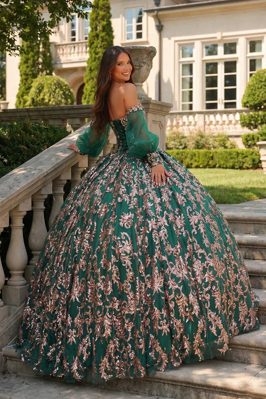 Emerald ball gown with gold glitter details, cold shoulder and sheer sleeves outdoors