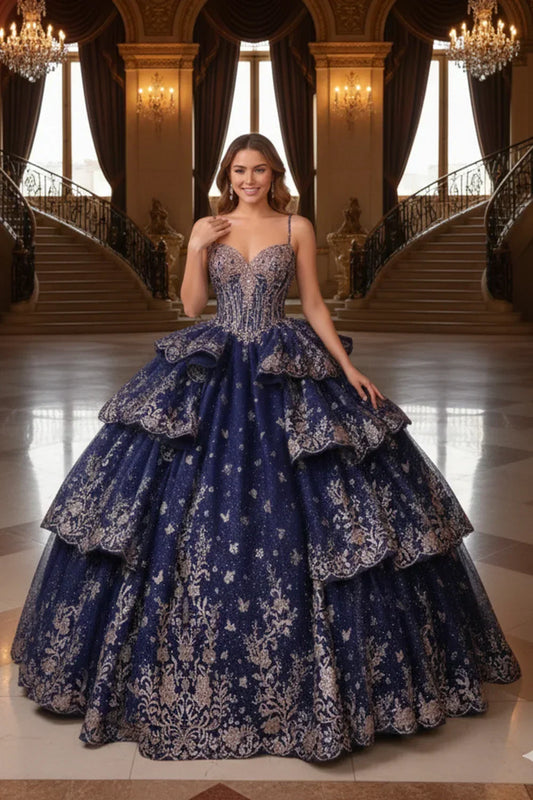 Woman in ornate navy blue layered ruffled ball gown with gold embroidery in grand hall
