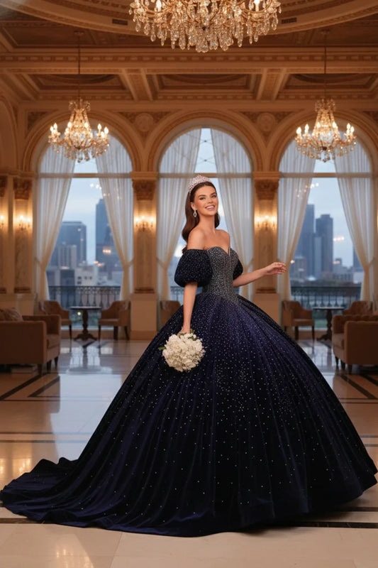 Woman in navy blue sparkle ball gown with tiara, holding bouquet in elegant ballroom