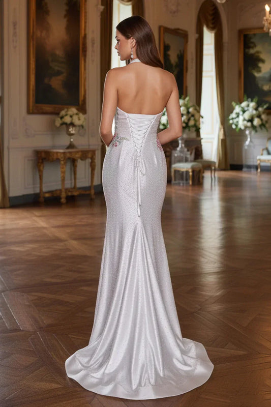 Elegant woman in a backless satin mermaid prom dress with halter neck and floral embroidery