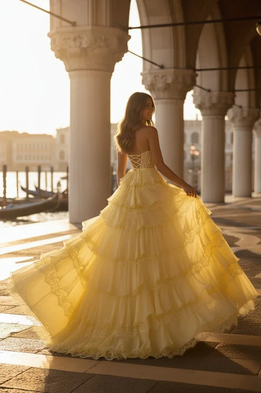 Back view of Sevoba butter yellow tiered ruffle prom dress, showing lace-up corset back, structured waist and layered skirt that flows lightly when walking