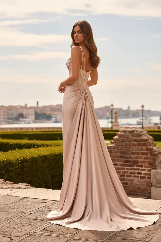 Woman in elegant champagne satin mermaid prom dress with spaghetti straps outdoors