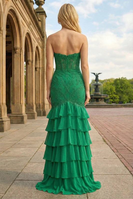 Back view of a woman in a green strapless ruffled mermaid prom dress outdoors
