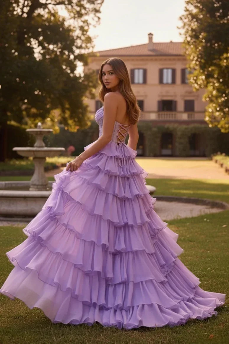 Woman wearing a lavender strapless ruffle tiered corset prom dress in a garden setting