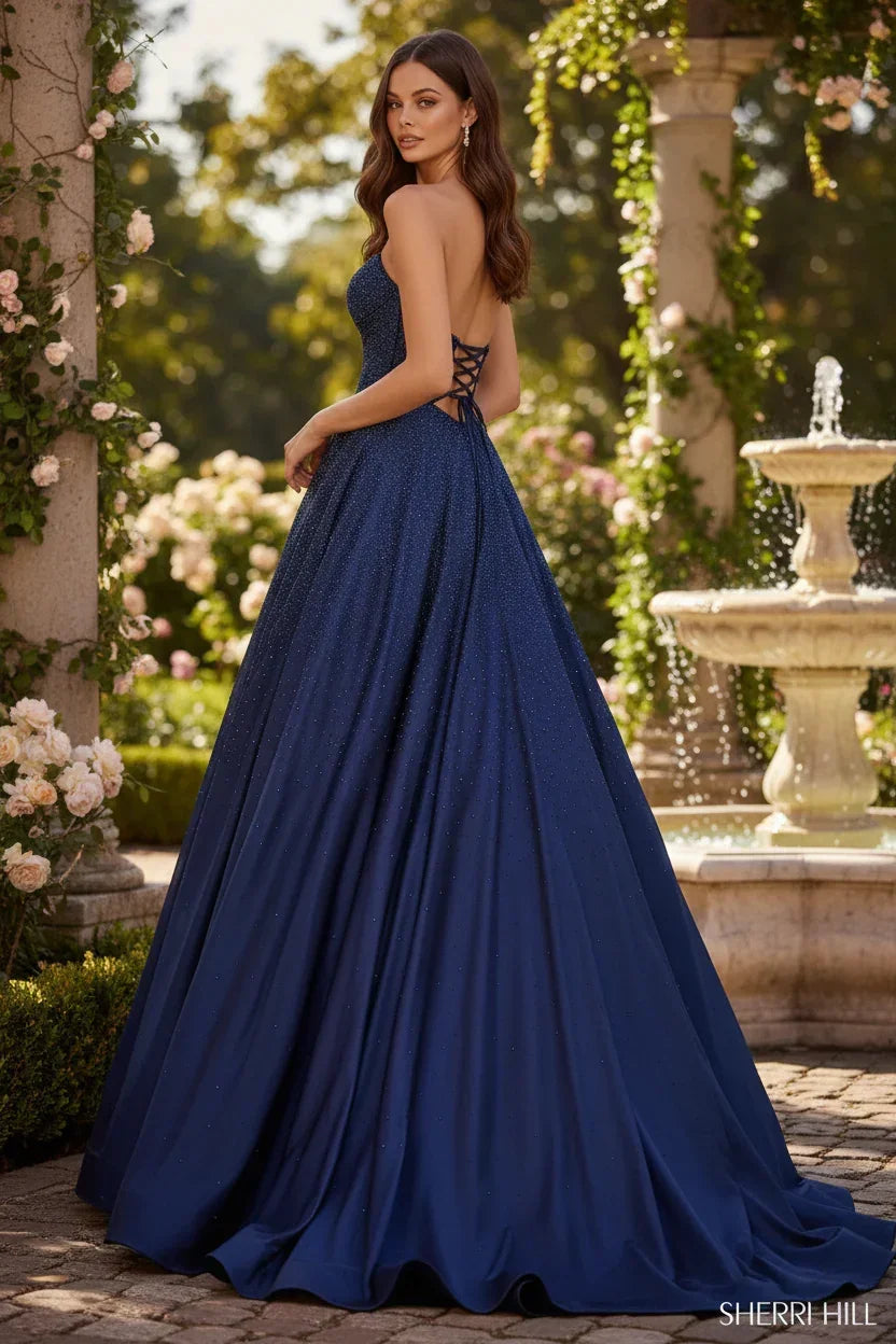 Woman in sparkling navy A-line prom dress with sweetheart neckline and lace-up back outdoors