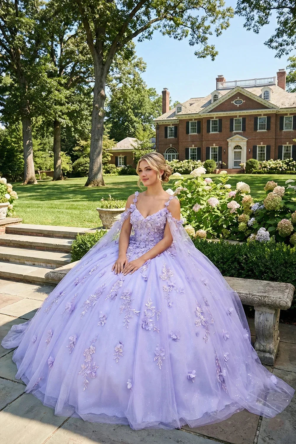 Woman in lilac ball gown with 3D floral appliques and sheer cape in garden setting