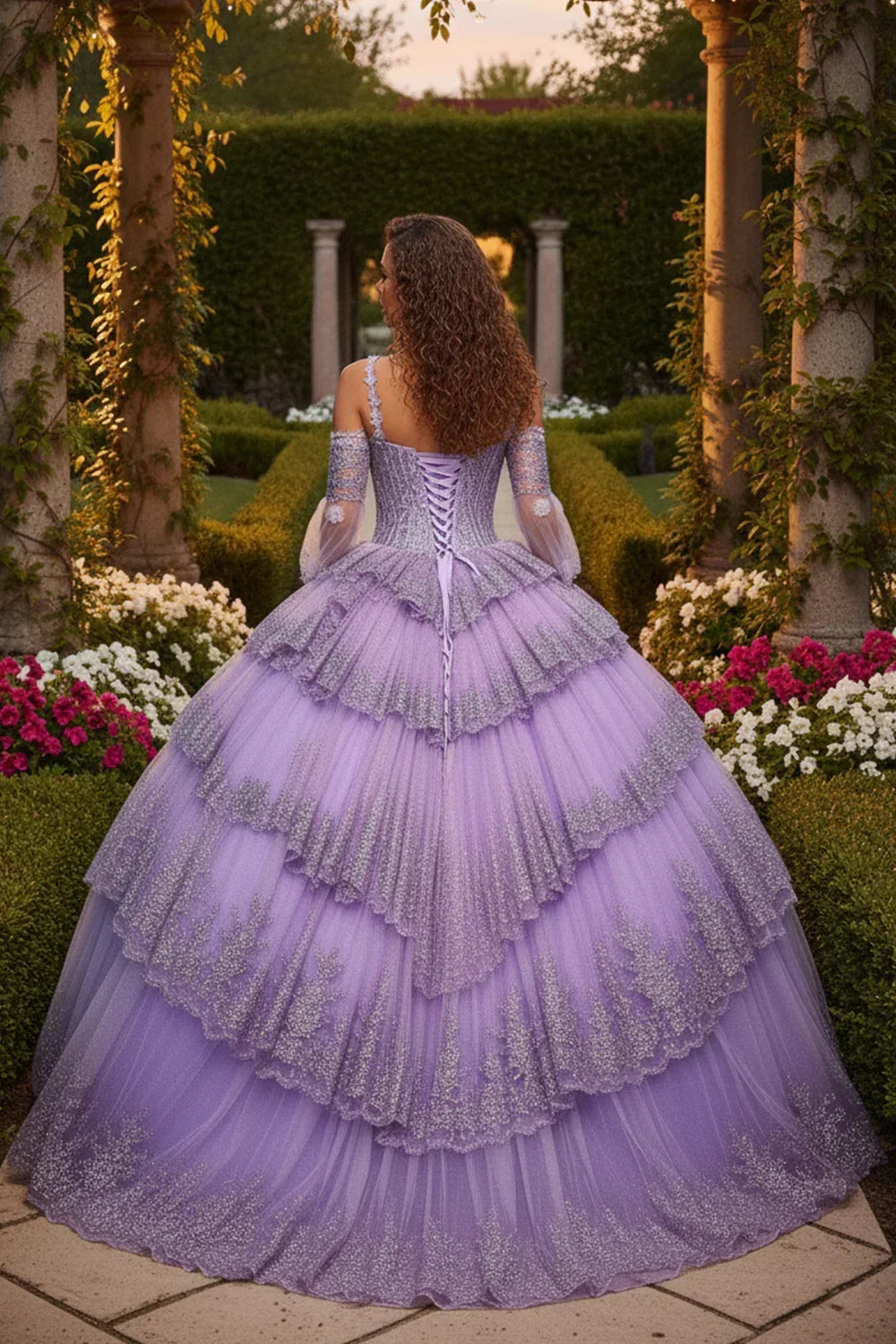 Woman in a lavender layered ruffled ball gown with glitter details standing in a garden.