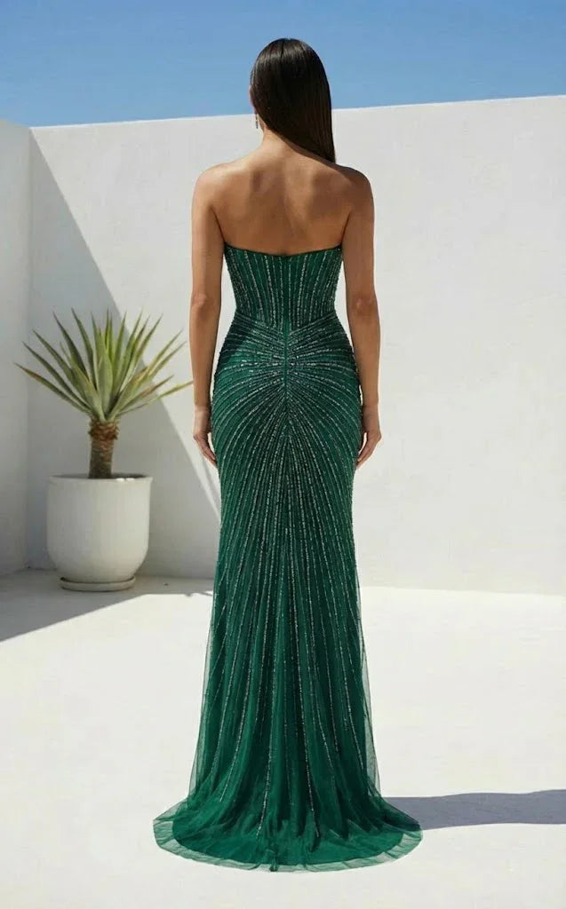 Woman wearing a strapless green beaded prom dress with sheath silhouette and elegant shimmer