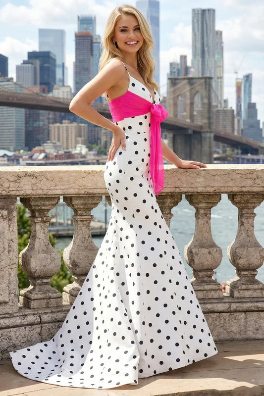 Woman in a white mermaid V-neck polka dot prom dress with pink corset bow, city backdrop