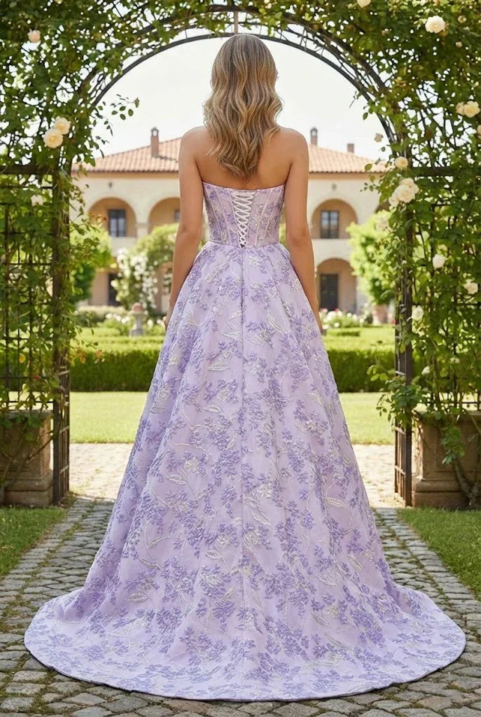 Back view of a woman in a lilac floral A-line prom dress with corset bodice outdoors