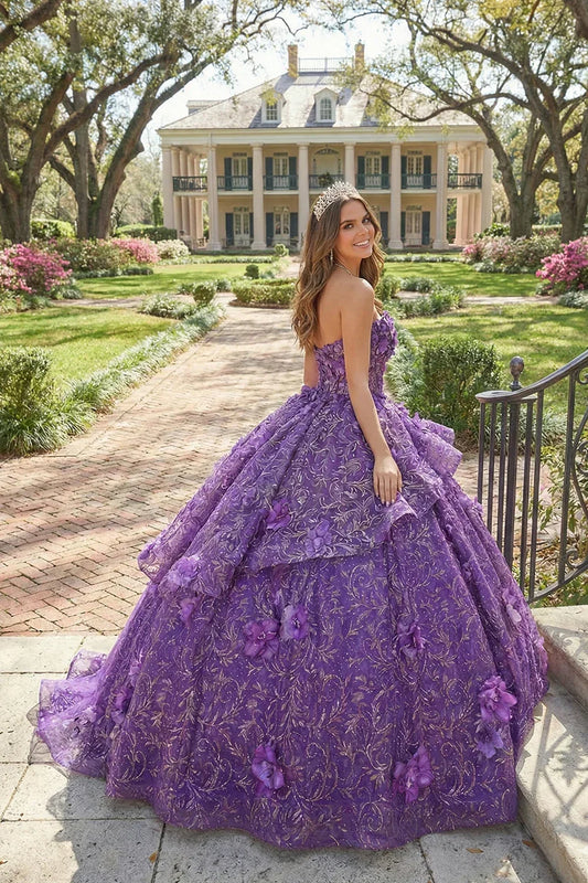Smiling woman outdoors in a purple 3D floral ball gown with ruffles, wearing a tiara.