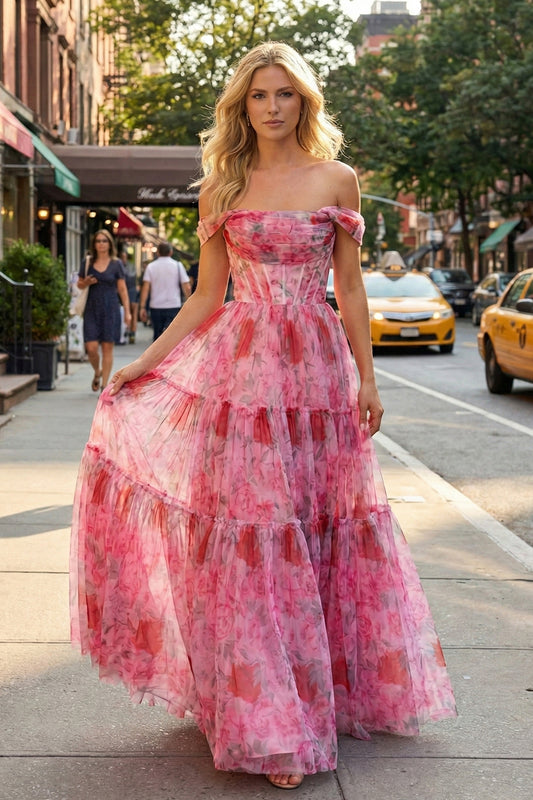 Sevoba pink floral print tiered tulle prom dress featuring an off-the-shoulder corset bodice and rose pattern, front view in city street setting