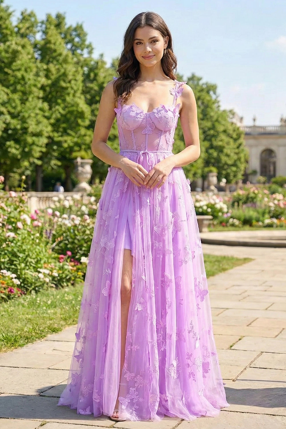 Sevoba lilac purple tulle prom dress featuring 3D butterfly appliqués, a sheer corset bodice, and high leg slit, front view in outdoor garden setting.