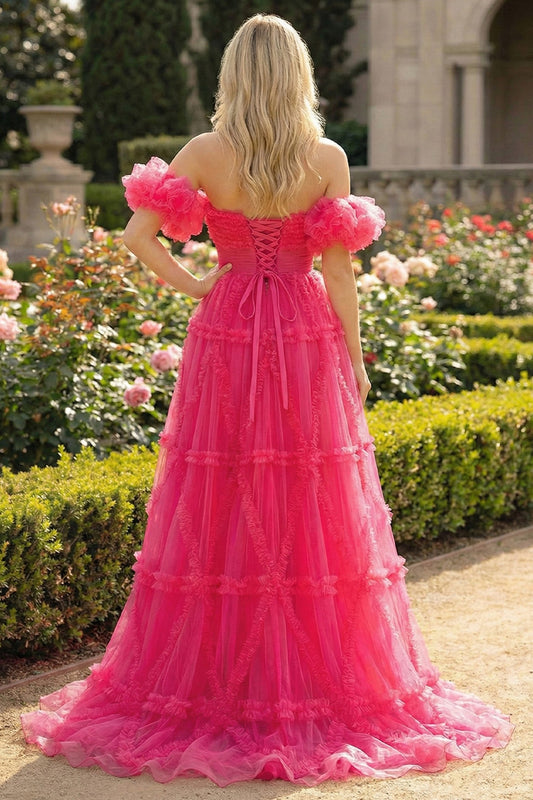 Back view of Sevoba fuchsia pink tulle ball gown showing a lace-up corset back and voluminous ruffled skirt, garden background