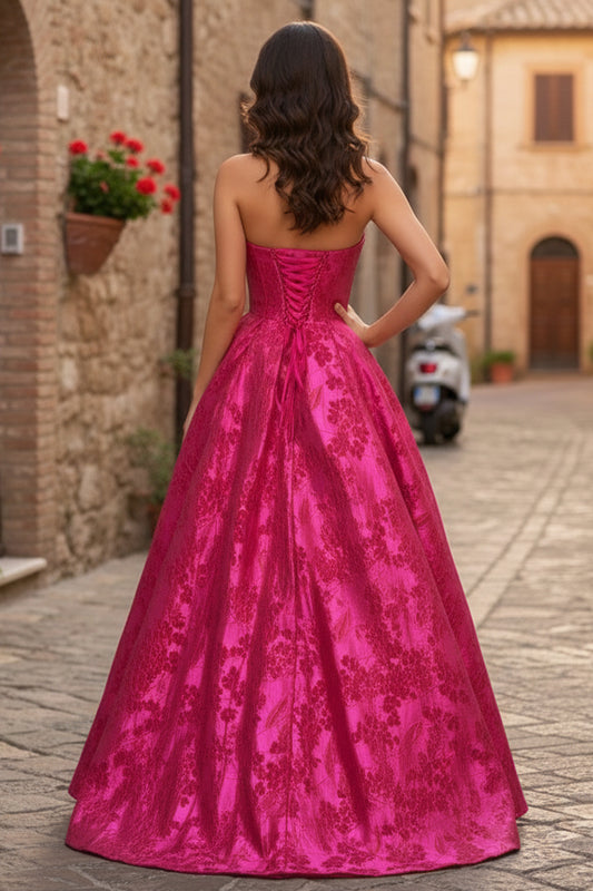 Back view of Sevoba fuchsia jacquard evening gown showing a lace-up corset back and voluminous A-line skirt, outdoor street background