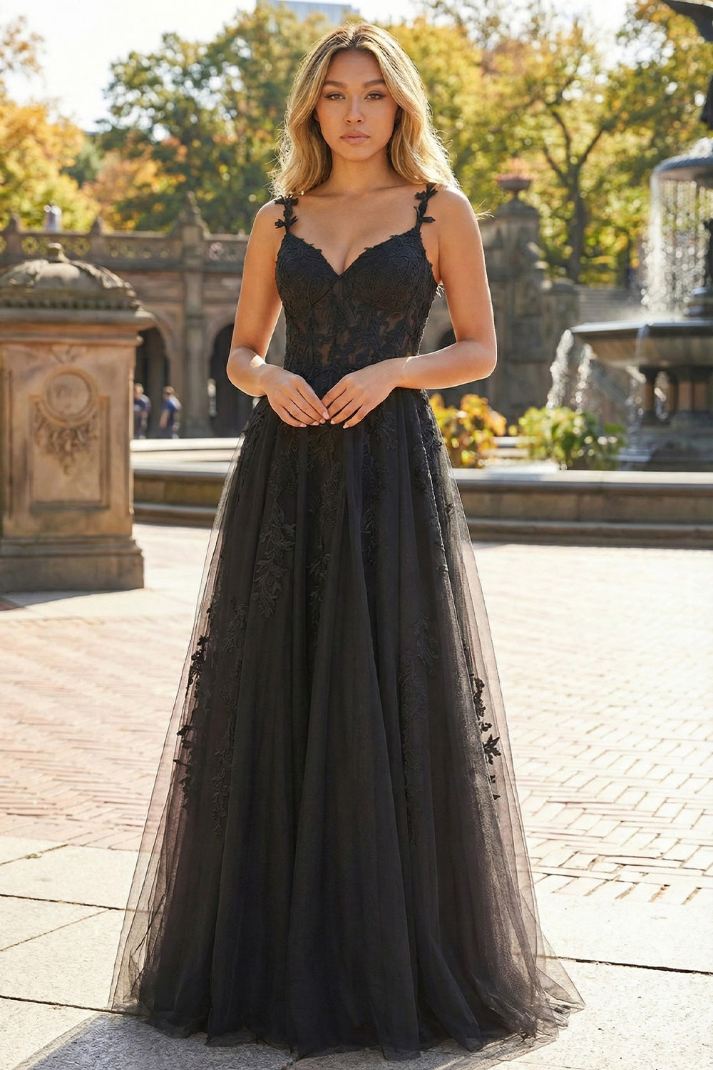 Sevoba black tulle A-line prom dress featuring a sheer floral lace corset bodice and flower-embellished straps, front view with park background