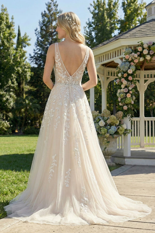 Back view of Sevoba ivory lace bridal gown showing a V-back with illusion mesh and a row of covered buttons, garden background