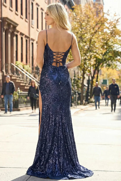 Back view of Sevoba dark blue sequin evening gown showing a lace-up corset back and fitted silhouette, city street background. 
