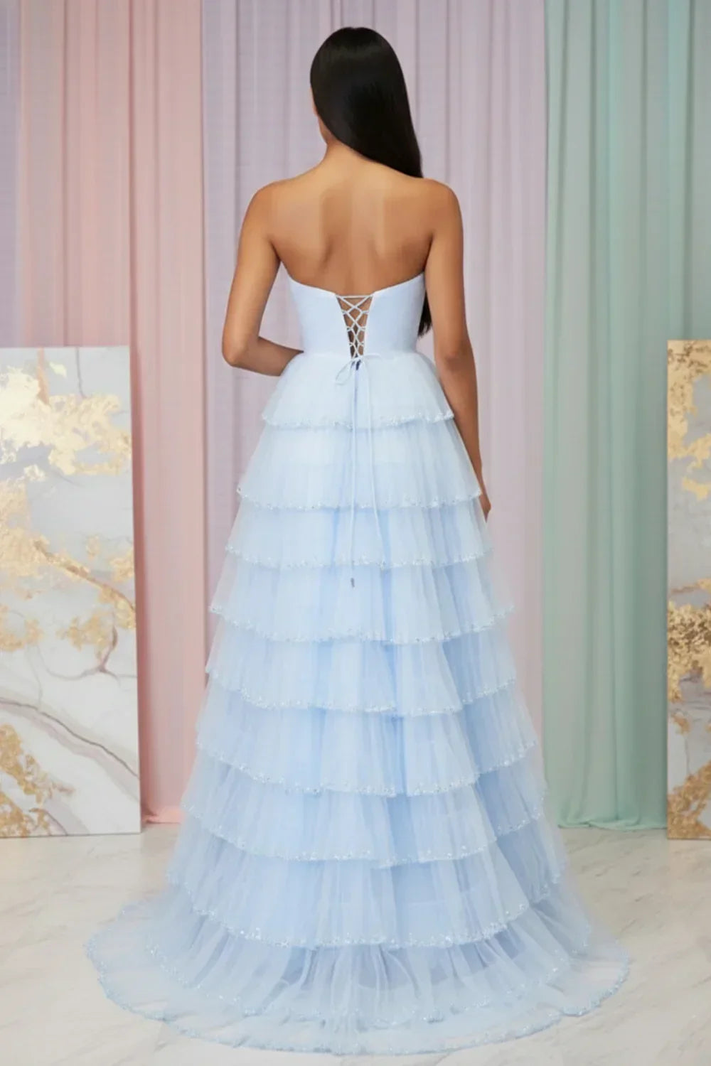 Back view of Sevoba light blue strapless tulle evening gown showing a lace-up corset back and cascading tiered skirt
