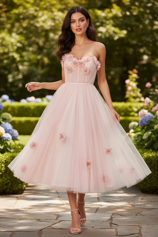 Sevoba strapless blush pink tea-length prom dress featuring 3D floral appliqués and a corset bodice, front view on garden path