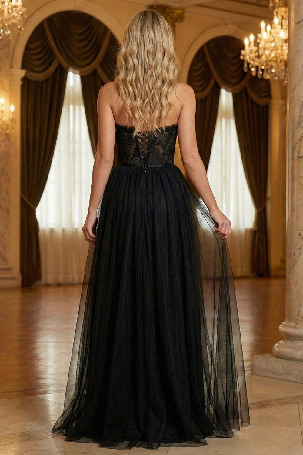 Back view of Sevoba black gothic tulle evening gown showing a lace-up corset back and flowy floor-length skirt, ballroom background.