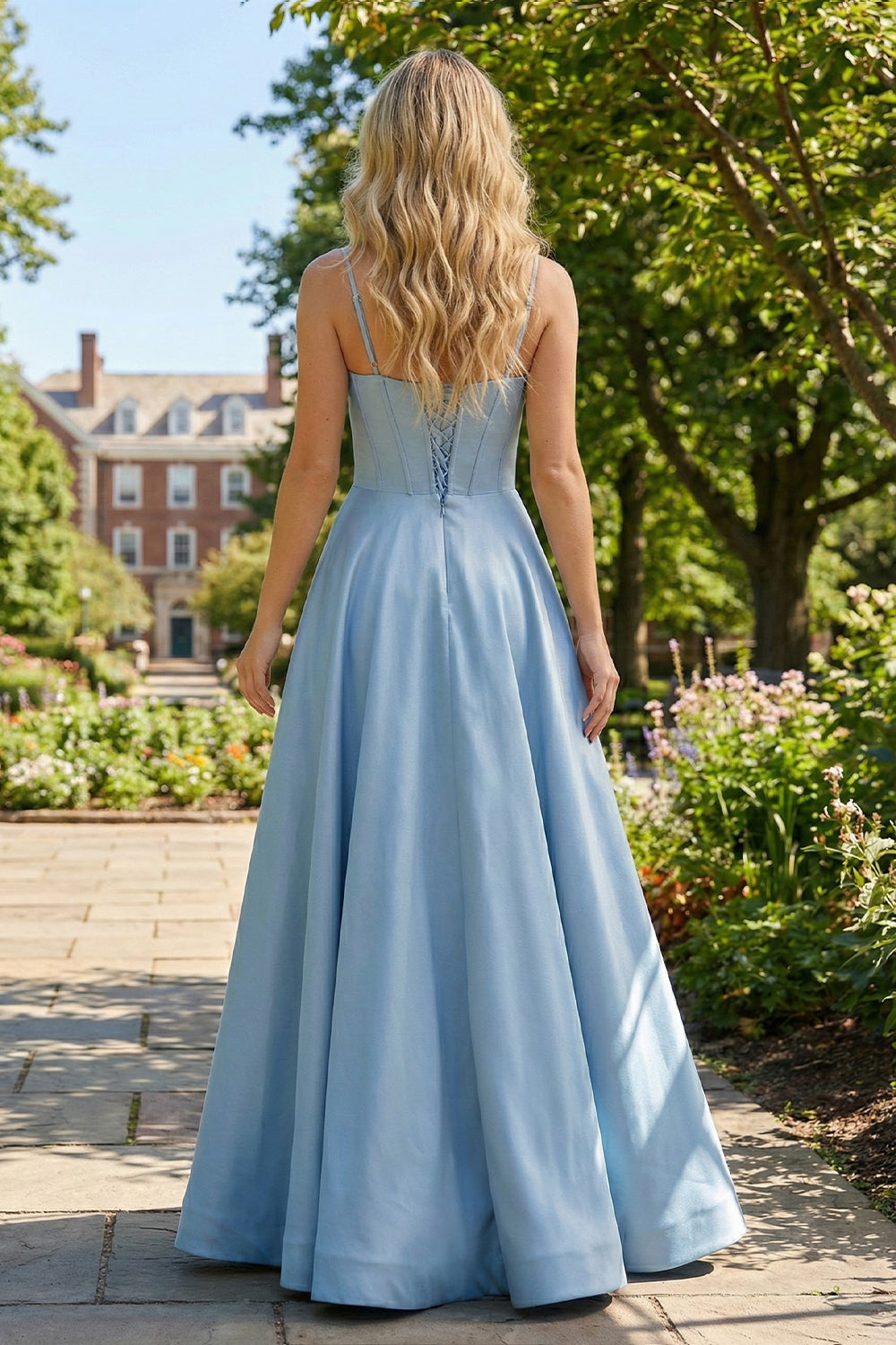 Back view of Sevoba cornflower blue satin evening gown showing a lace-up corset back and voluminous floor-length skirt, outdoor brick building background
