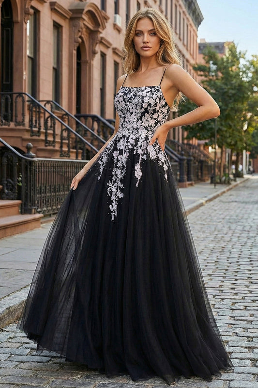 Sevoba black tulle A-line prom dress featuring white floral embroidery and spaghetti straps, full-length front view on city street
