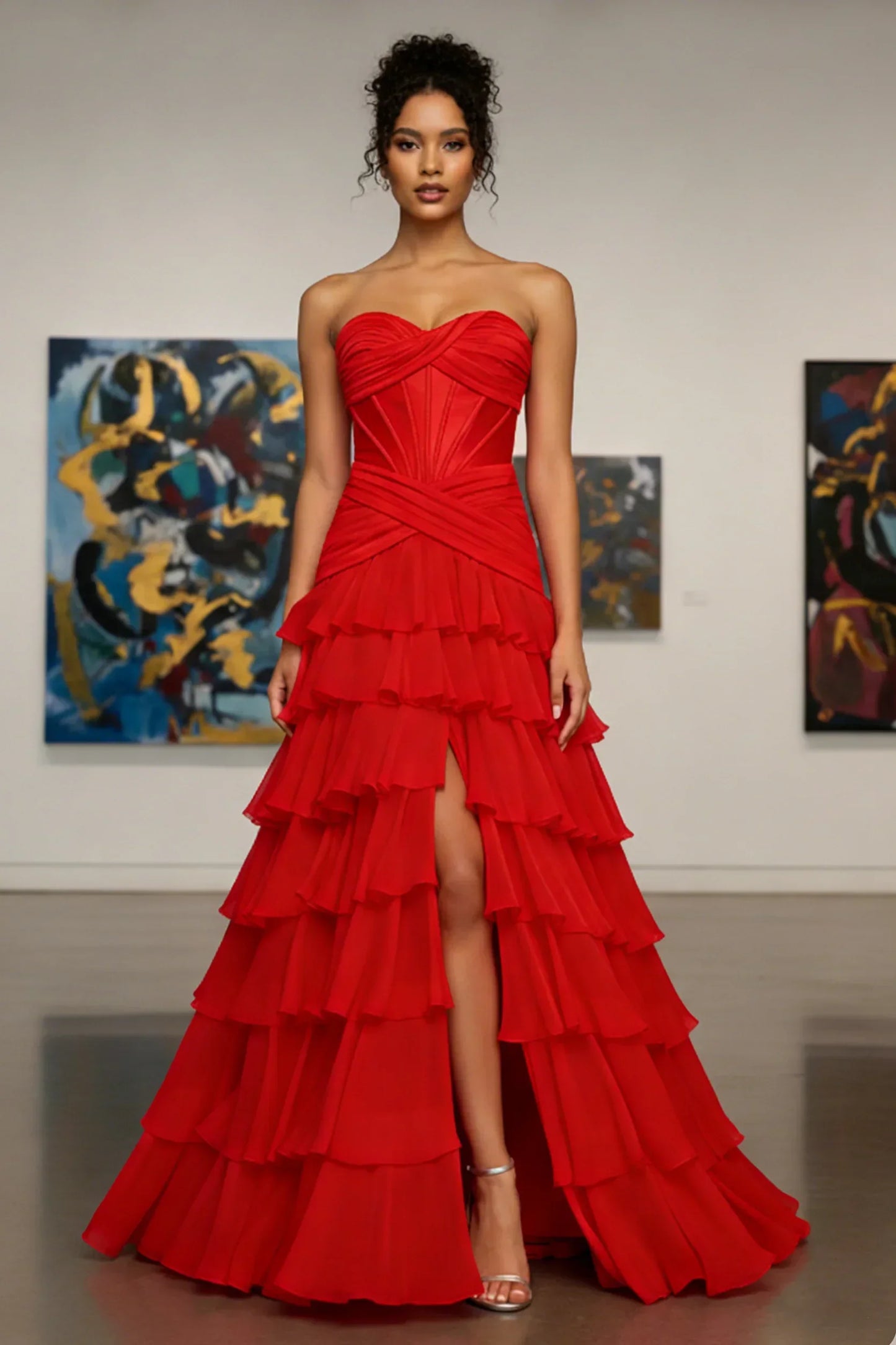 Woman in strapless red ruffled evening gown with high slit, standing in an art gallery