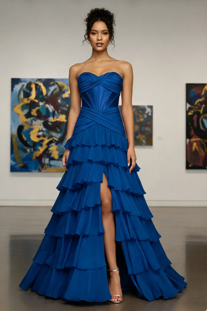 Woman in strapless royal blue ruffled evening gown with front slit, perfect for prom or formal event