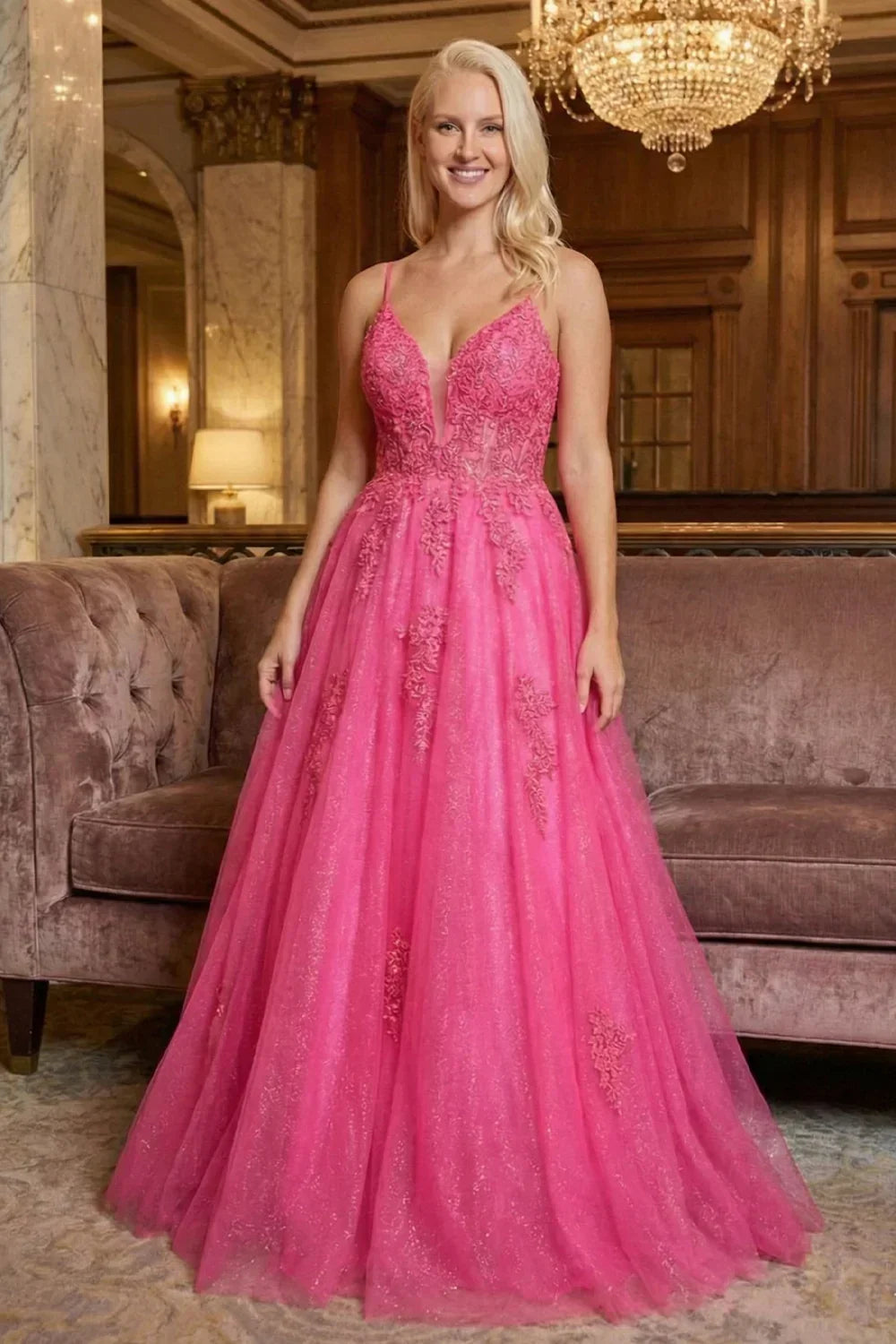 Sevoba hot pink glitter tulle A-line prom dress featuring a floral lace corset bodice and V-neckline, front view in hotel lobby setting