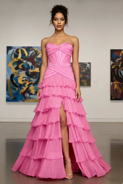 Woman in strapless pink tiered ruffle gown with side slit, ideal for prom or formal events