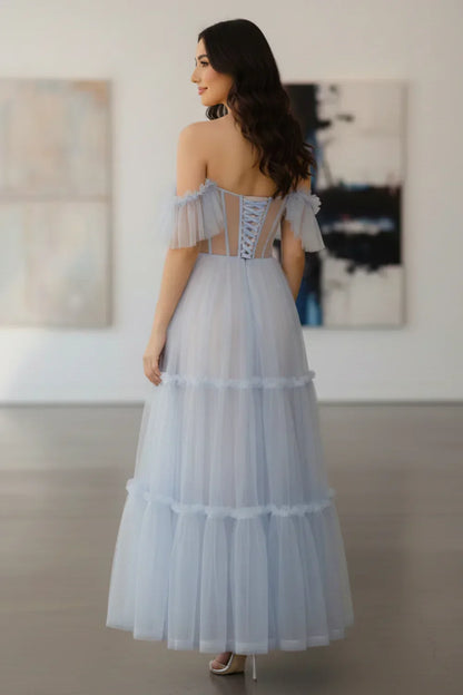 Back view of Sevoba pastel blue midi evening gown showing a lace-up corset back and off-the-shoulder ruffle sleeves, indoor gallery backgroun