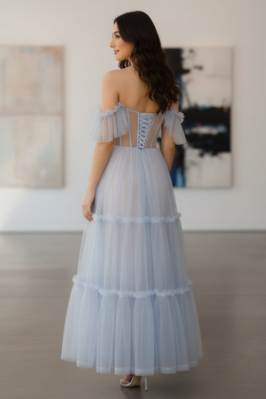Back view of Sevoba pastel blue midi evening gown showing a lace-up corset back and off-the-shoulder ruffle sleeves, indoor gallery backgroun