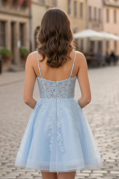 Back view of a woman in a light blue A-line spaghetti strap lace homecoming dress outdoors