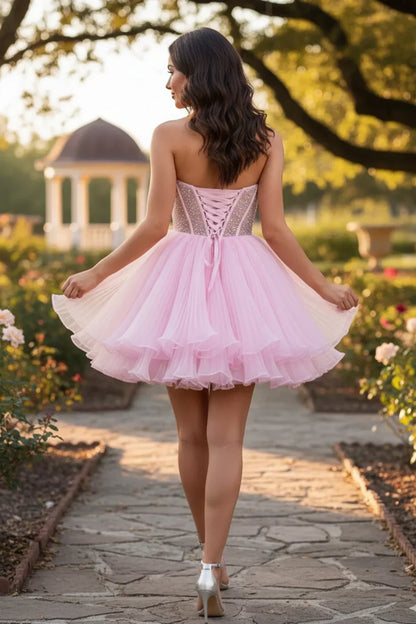 Woman in pink strapless ruffled short homecoming dress with corset back and layered skirt outdoors