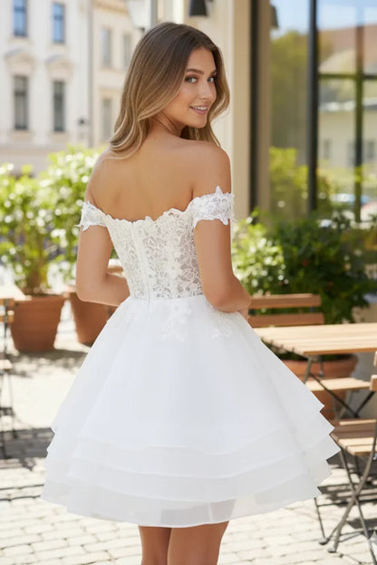 Woman in a white off-the-shoulder lace A-line tulle prom dress outdoors
